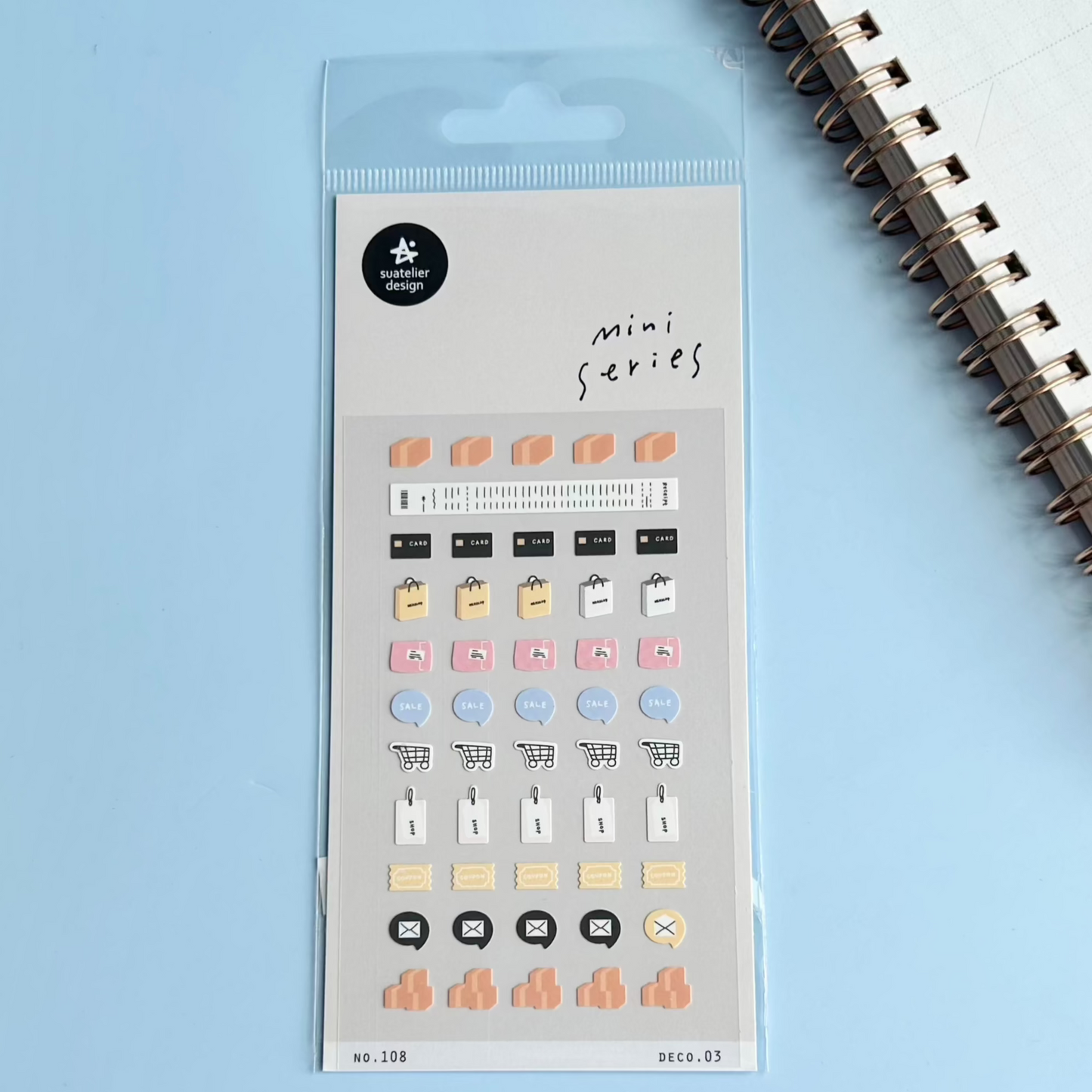 Packaged mini series stickers with a spiral notebook on a light blue background
