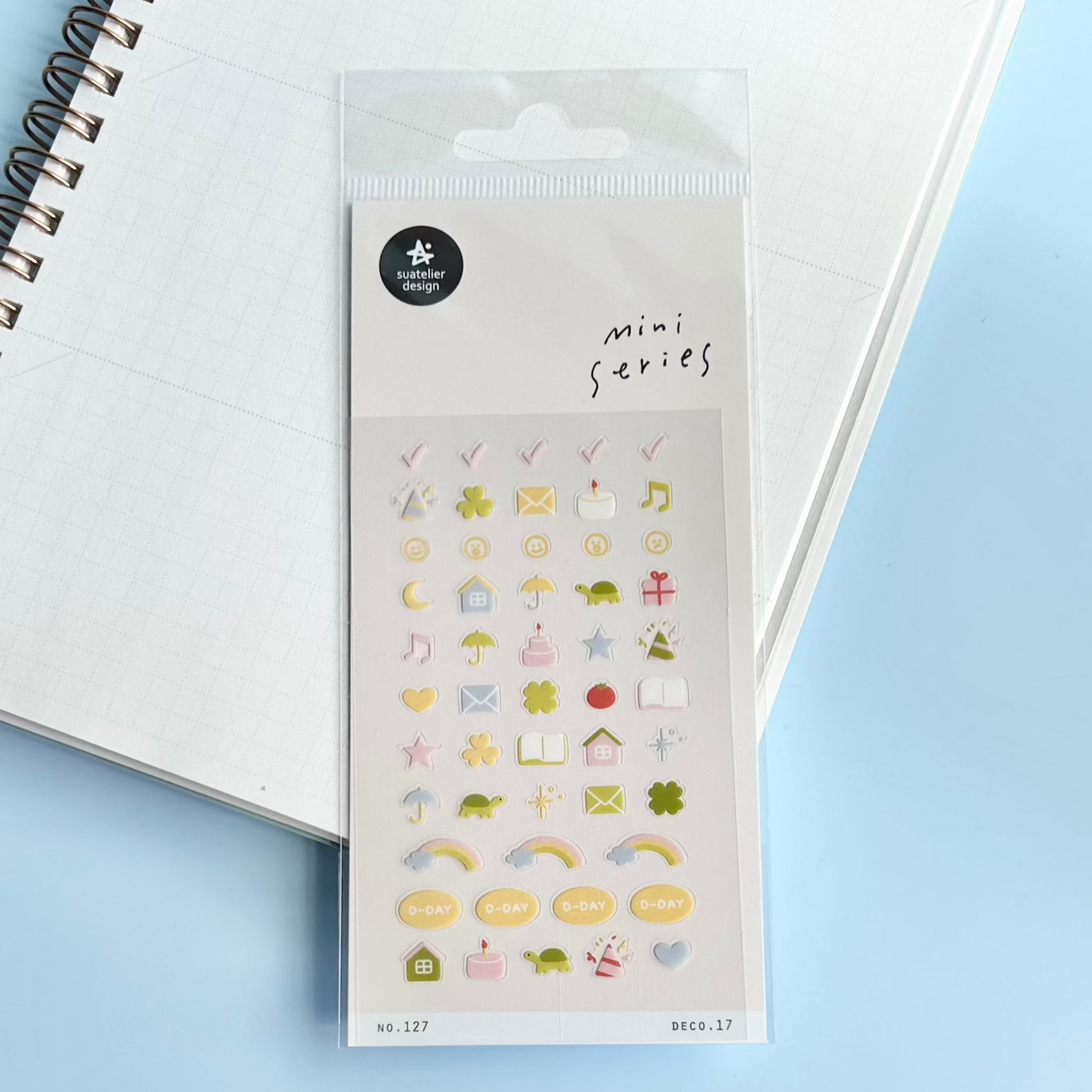 Packaged mini series stickers with various icons on a light blue background