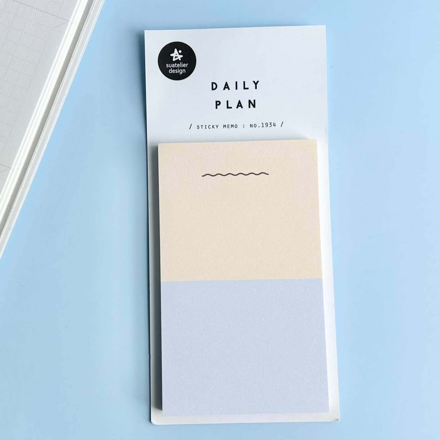 Sticky memo pad with 'Daily Plan' label on a light blue background