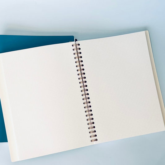Open notebook with spiral binding on a light blue background