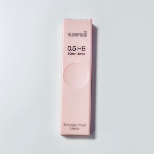 Pink pack of Uni brand 0.5 HB leads on a light gray background