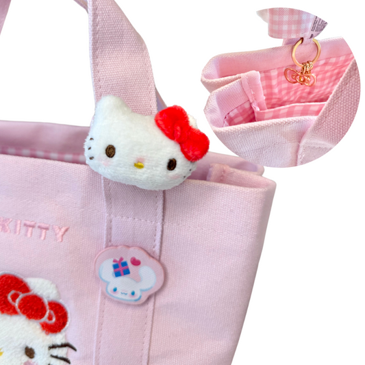 Pink bag with Hello Kitty character and accessories on a white background