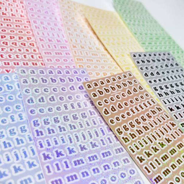 Sheets of multicolored alphabet stickers arranged in rows, with each row featuring different letters of the alphabet.