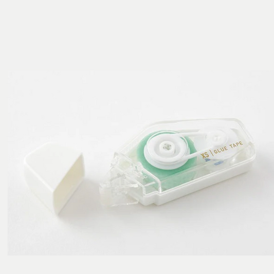 A small, clear case glue tape dispenser with a white tape visible at the top. The case is labeled with 'XS Glue Tape' and has a green accent around the dispenser wheel.