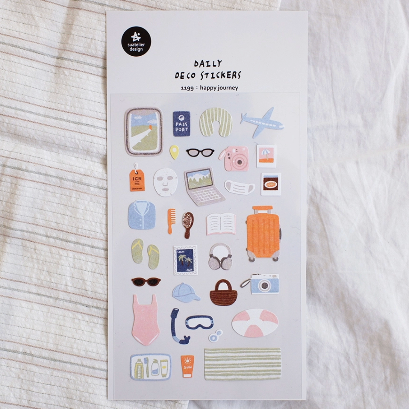 Sheet of decorative stickers with travel-themed designs on a textured surface