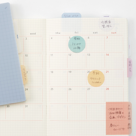 Calendar with hand-written notes and colorful stickers on a white background