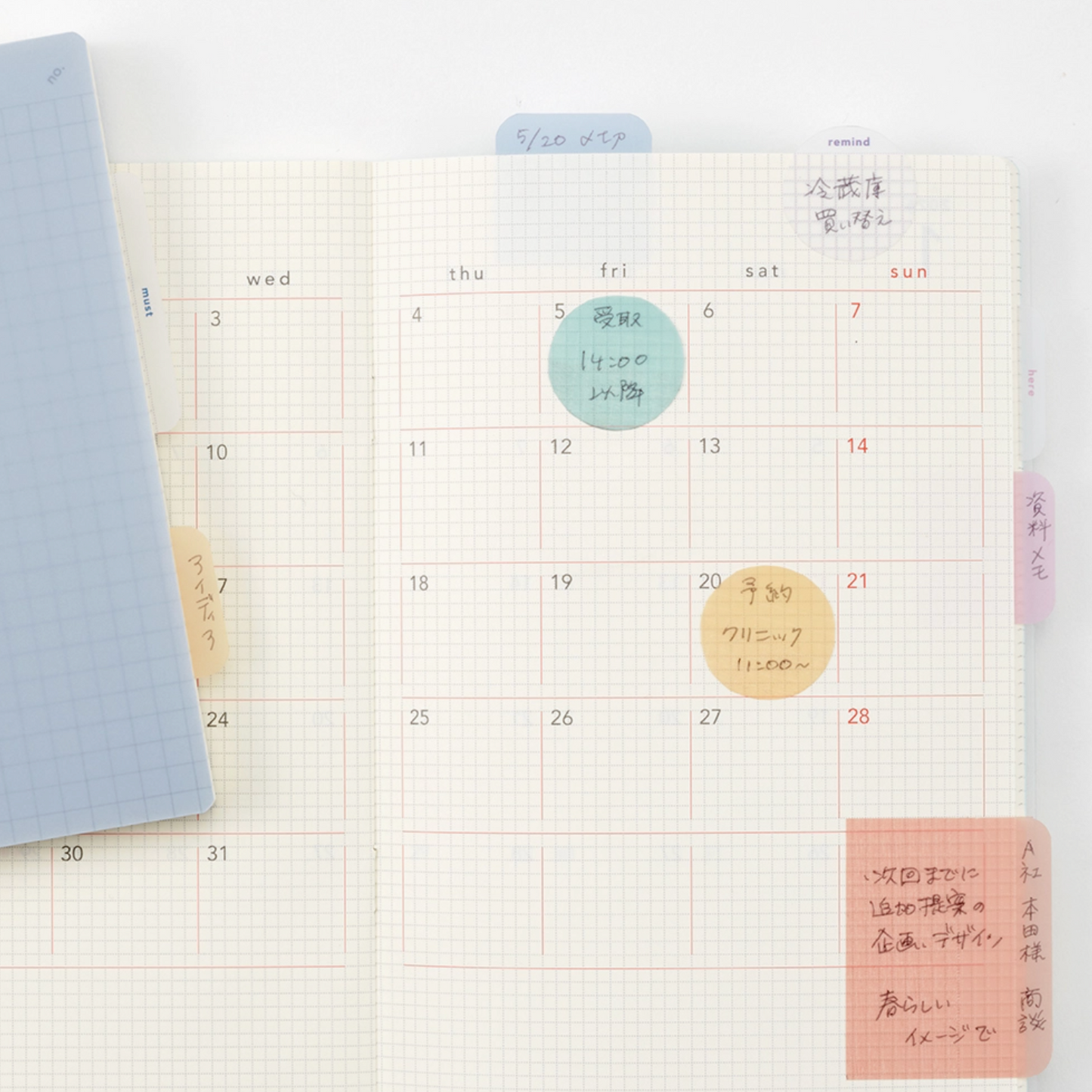 Calendar page with hand-written notes and colorful stickers on a grid background