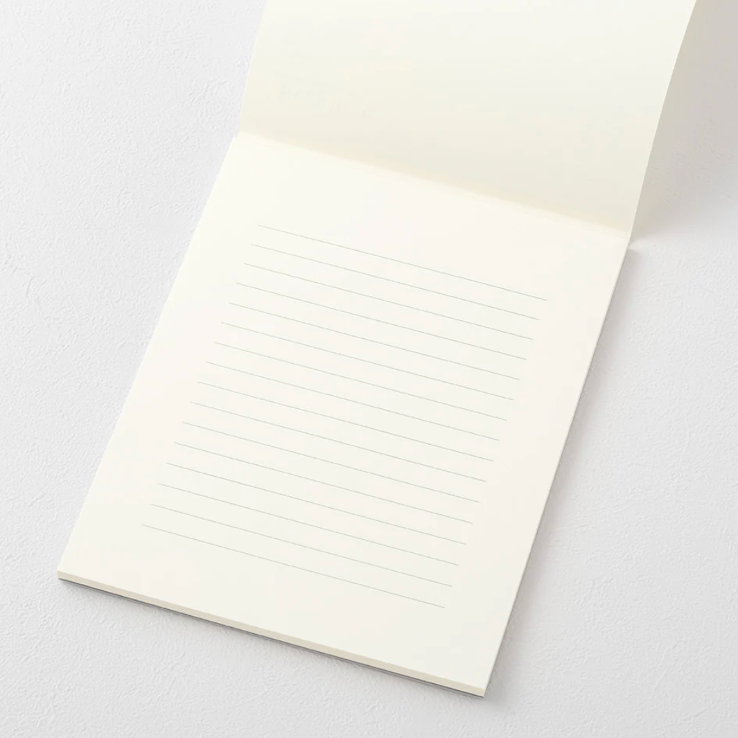 White notebook with lined pages on a light gray background