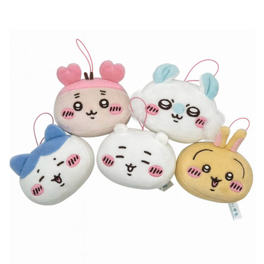 Set of five cartoon-style face-shaped keychains on a white background