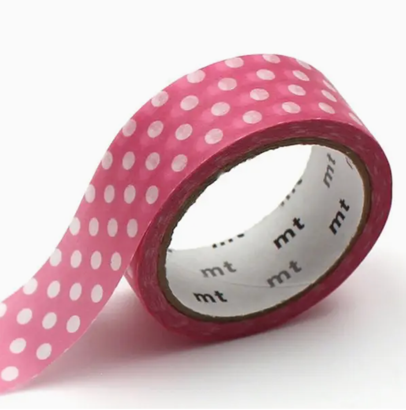 Roll of pink tape with white polka dots on a white background