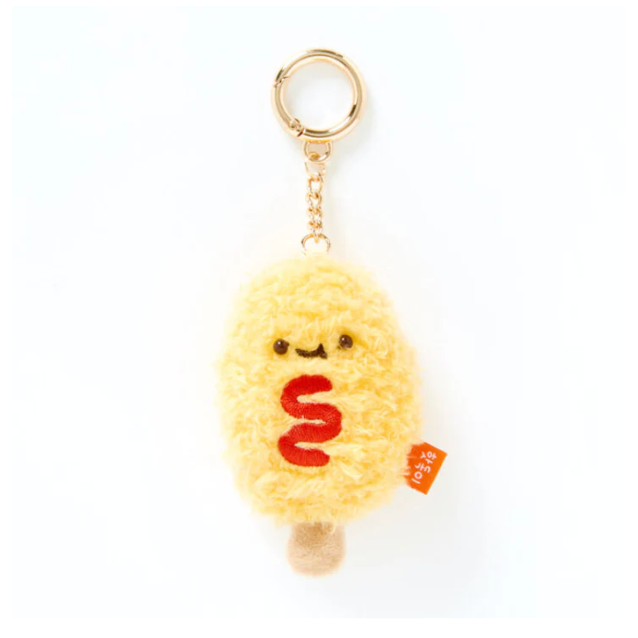 A yellow fluffy plush keychain shaped like a cute character with a red wavy line for a mouth, attached to a gold metal key ring, on a plain white background.