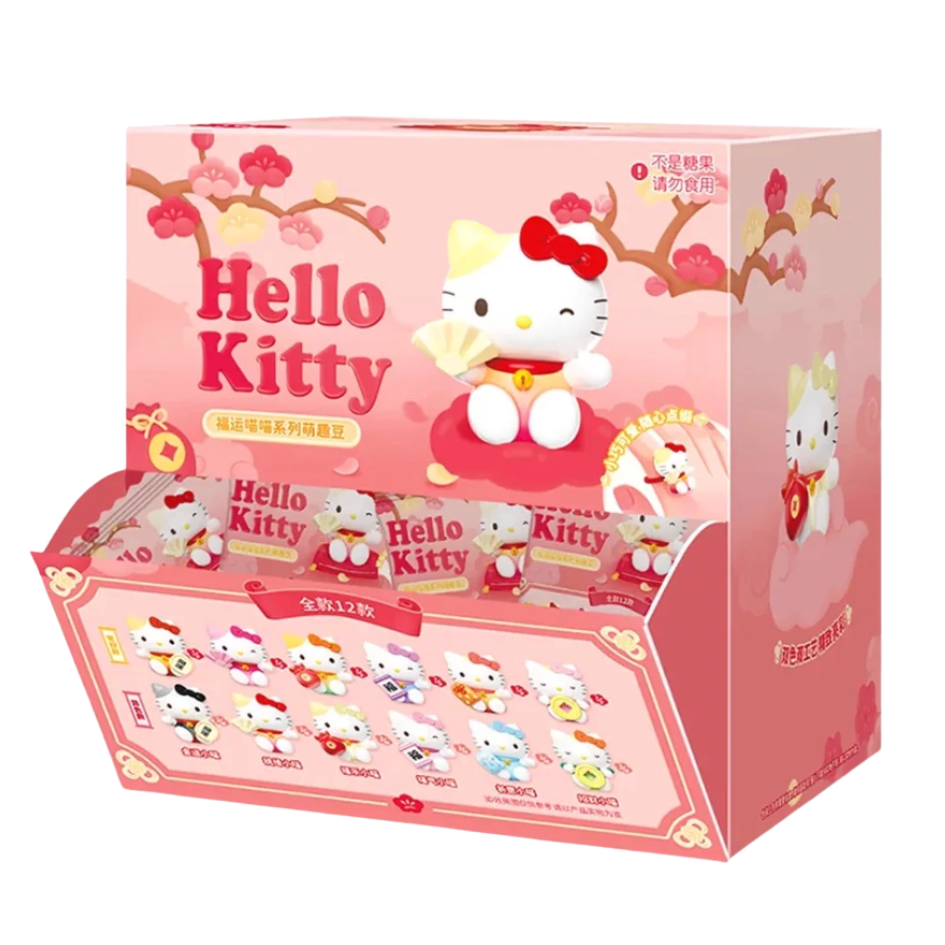 A pink Hello Kitty blind box display tray containing multiple small Hello Kitty character packs, decorated with cherry blossom branches and a large Hello Kitty illustration on the front.