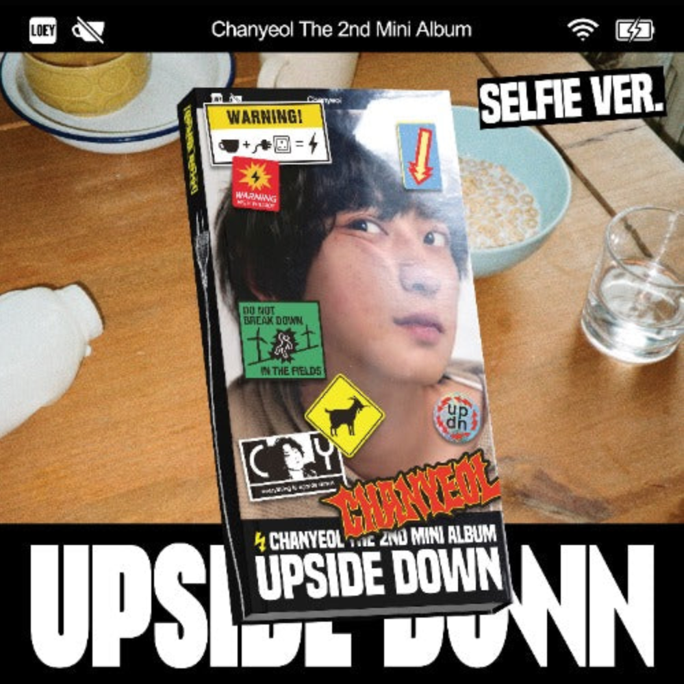 Album packaging for Chanyeol's 2nd mini album 'Upside Down' on a table with food items.