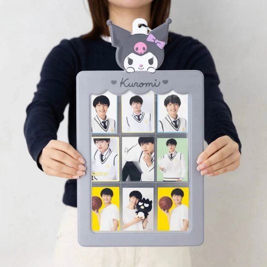 Person holding a photo frame with multiple images and a character on top, against a plain background.