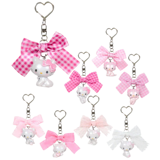 Set of Charmmy Kitty keychains with pink bows on a white background
