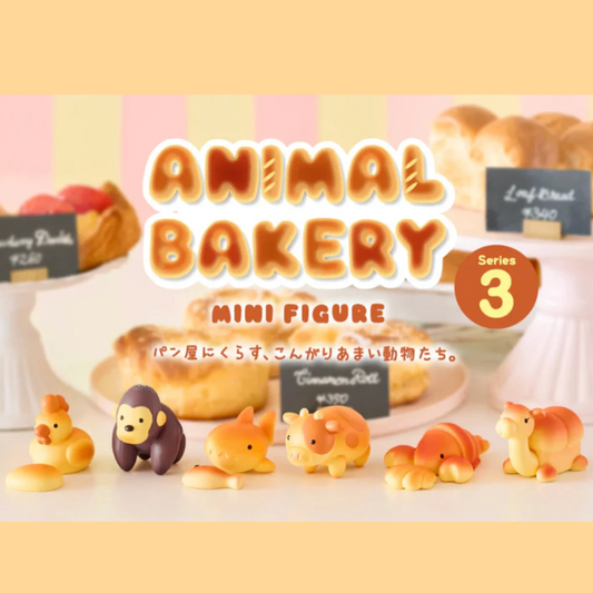 A set of cute animal-shaped mini figures displayed in front of a bakery-themed backdrop with breads and pastries. Large text reads 'ANIMAL BAKERY MINI FIGURE' with 'Series 3' in a badge, and small signs label figures such as Cinnamon Cake and Strawberry Pancake.