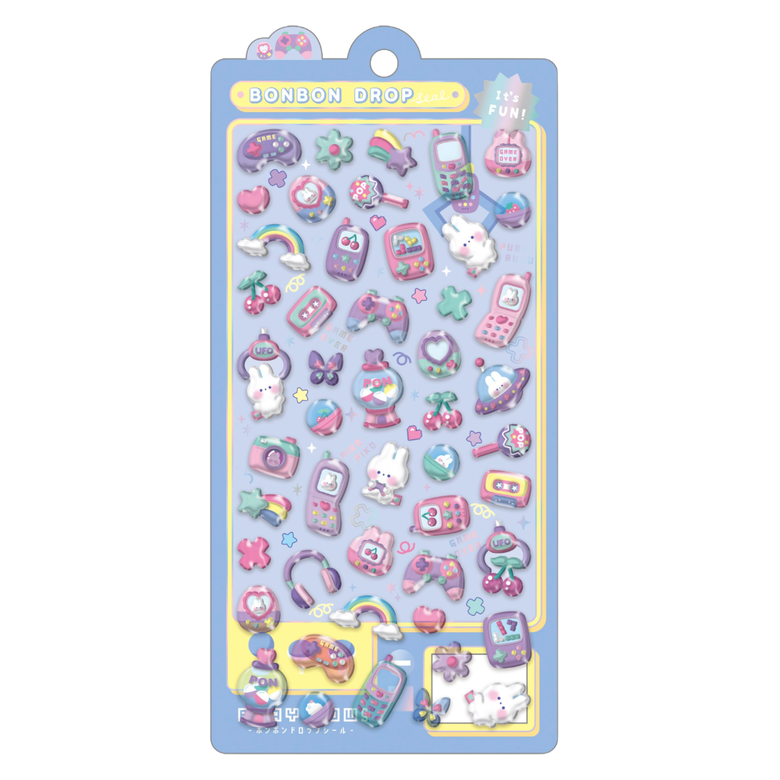 A sheet of cute pastel stickers on a blue backing card. The stickers feature various whimsical designs including a bunny, flip phone, camera, cassette tape, rainbow, cherries, and butterflies in pink, purple, yellow, and green.