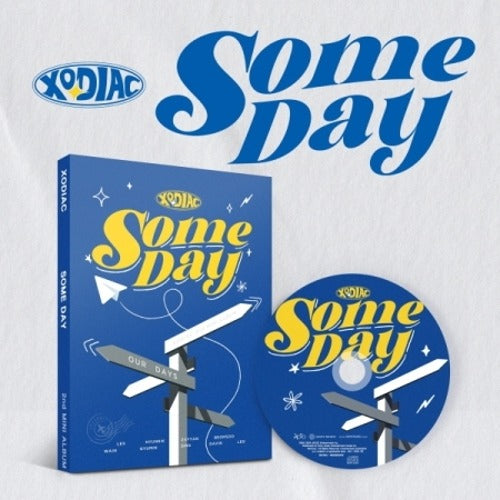 Photobook version of 'Some Day' by XODIAC with a blue and yellow cover featuring a compass and musical notes.