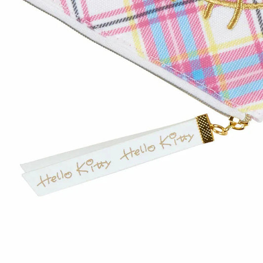 Close-up of a 'Hello Kitty' tag on a colorful plaid fabric background