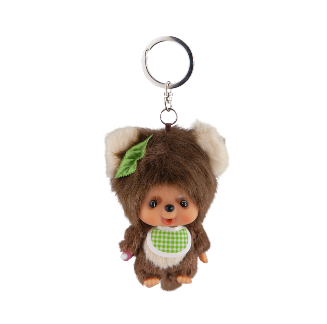 Monchhichi character with tan ears wearing green leaf on head and green checkered bib