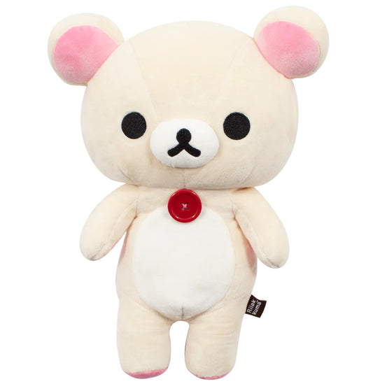 Plush toy bear with pink ears and a red button on a white background