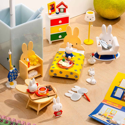 A collection of Miffy-themed miniature figures and accessories including a doll, furniture, and everyday items like clothing and a notebook.