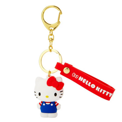 A Hello Kitty 3D key ring with a white character wearing a blue dress and red bow, attached to a red strap with the text 'GOHelloKitty' on a gold-colored keychain.