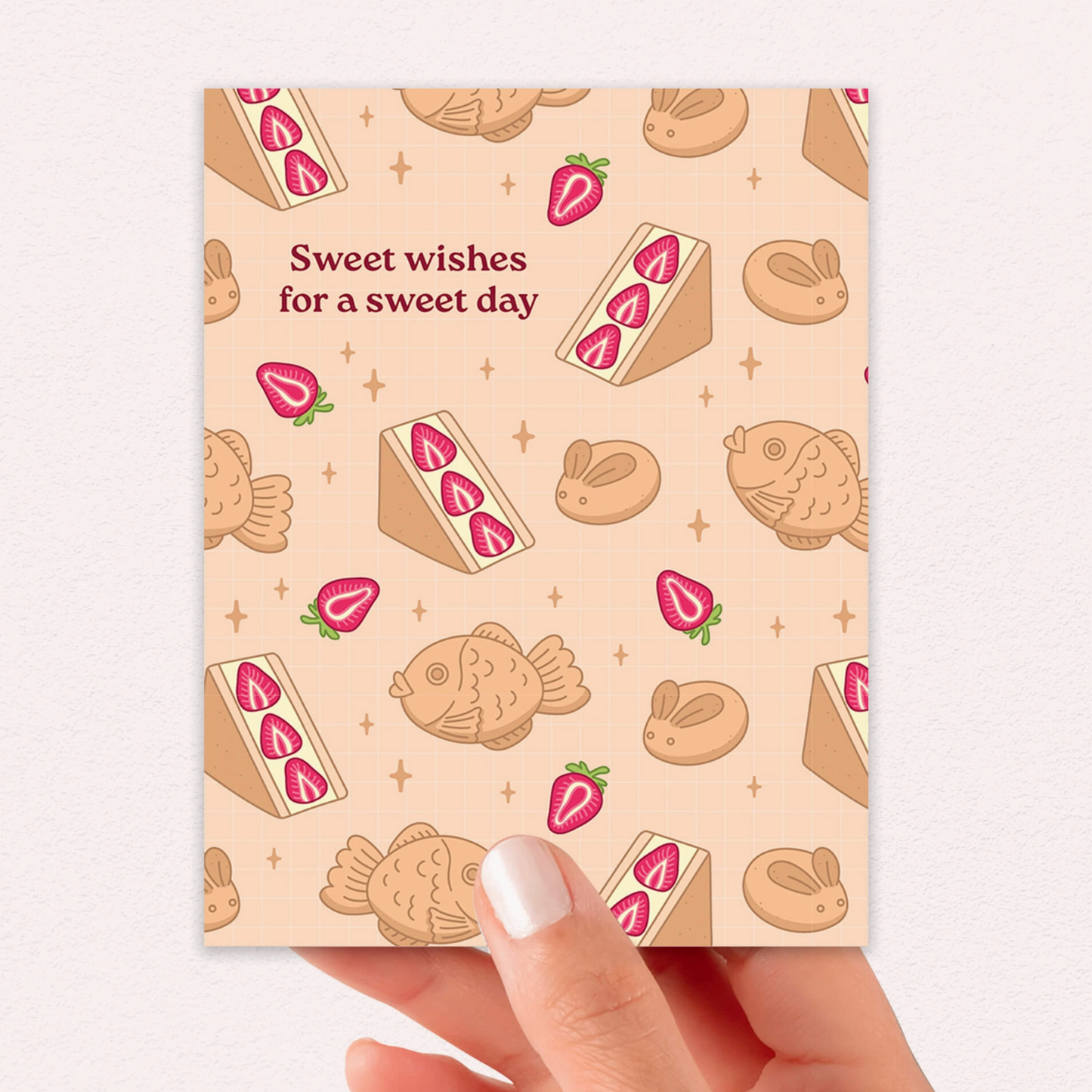 Card with dessert illustrations and text 'Sweet wishes for a sweet day' held by a hand.