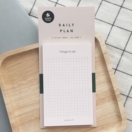 Daily plan sticky notes on a wooden tray with a checkered tablecloth background