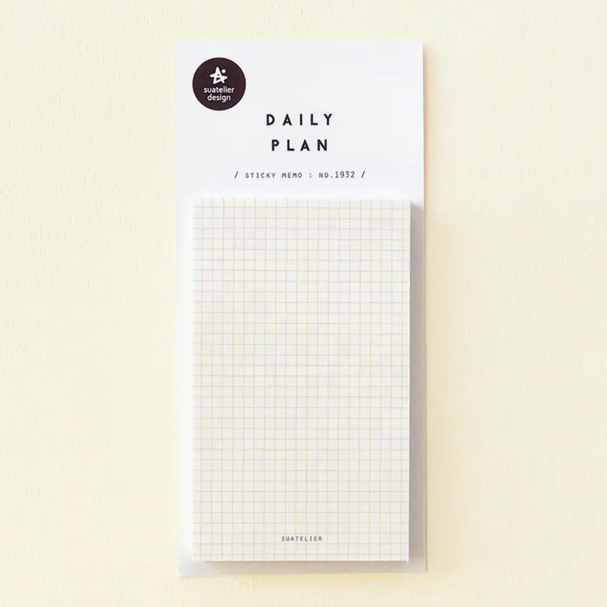 Daily plan sticky memo pad with grid pattern on a beige background