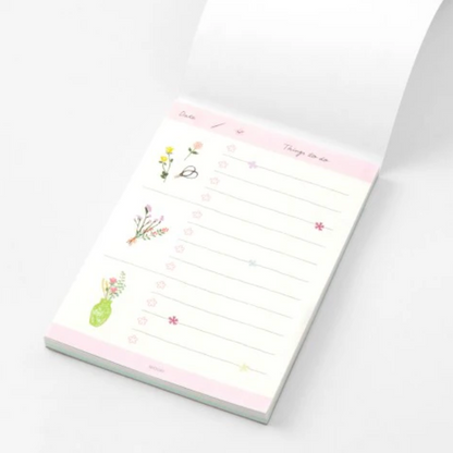 Notepad with floral designs on a white background
