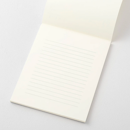 White notebook with lined pages on a light gray background