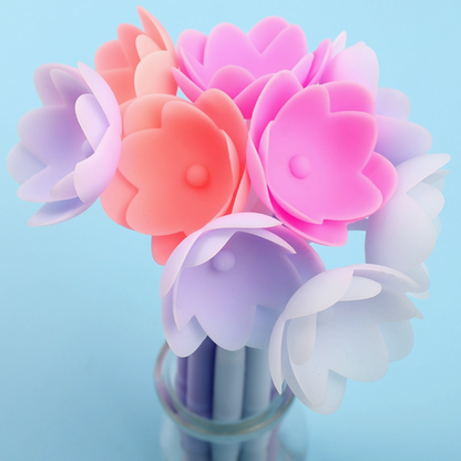 Colorful flower-shaped cotton swabs in a clear vase on a light blue background