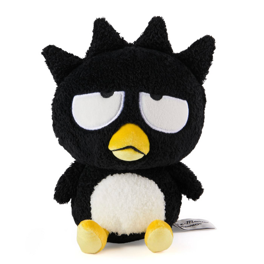 A black plush toy with a white belly, yellow beak and feet, and large white eyes, shown against a plain white background.