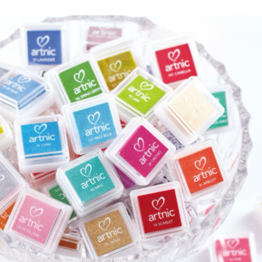 Bowl of multiple colors of ink pads with 'artnic' text.