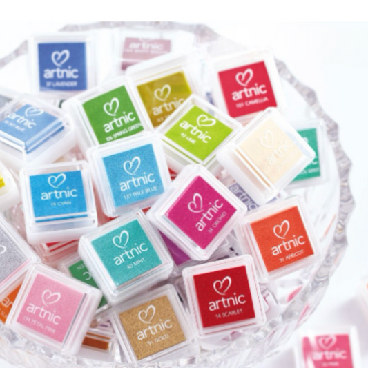 Bowl of multiple colors of ink pads with 'artnic' text.