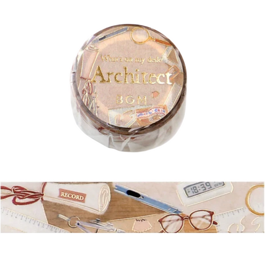 A roll of decorative washi tape with an 'Architect' theme, featuring a clear plastic lid with gold foil lettering and a printed design of desk accessories. A horizontal strip of the unrolled tape is shown below, displaying beige, pink, and brown tones with illustrations of a pencil, glasses, a clock, and a notebook.