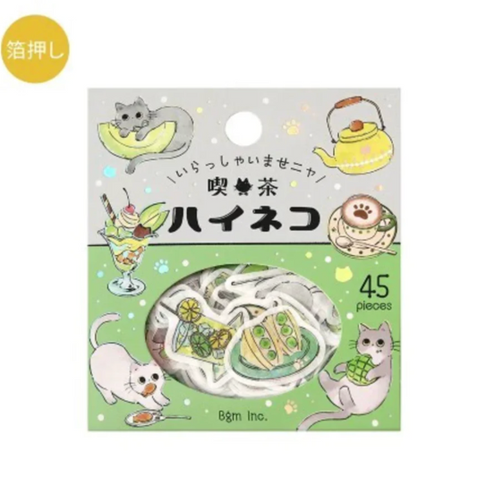 Packaged cat-themed hair tie on a white background. The product is a roll of white hair ties decorated with colorful illustrations of cats, tea, noodles, and desserts.