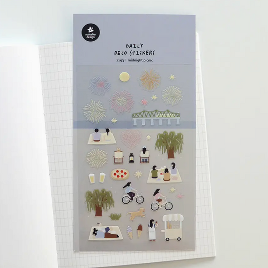 A sheet of daily desk stickers featuring minimalist illustrations of people, bicycles, trees, and picnic scenes, displayed on a white grid notebook.