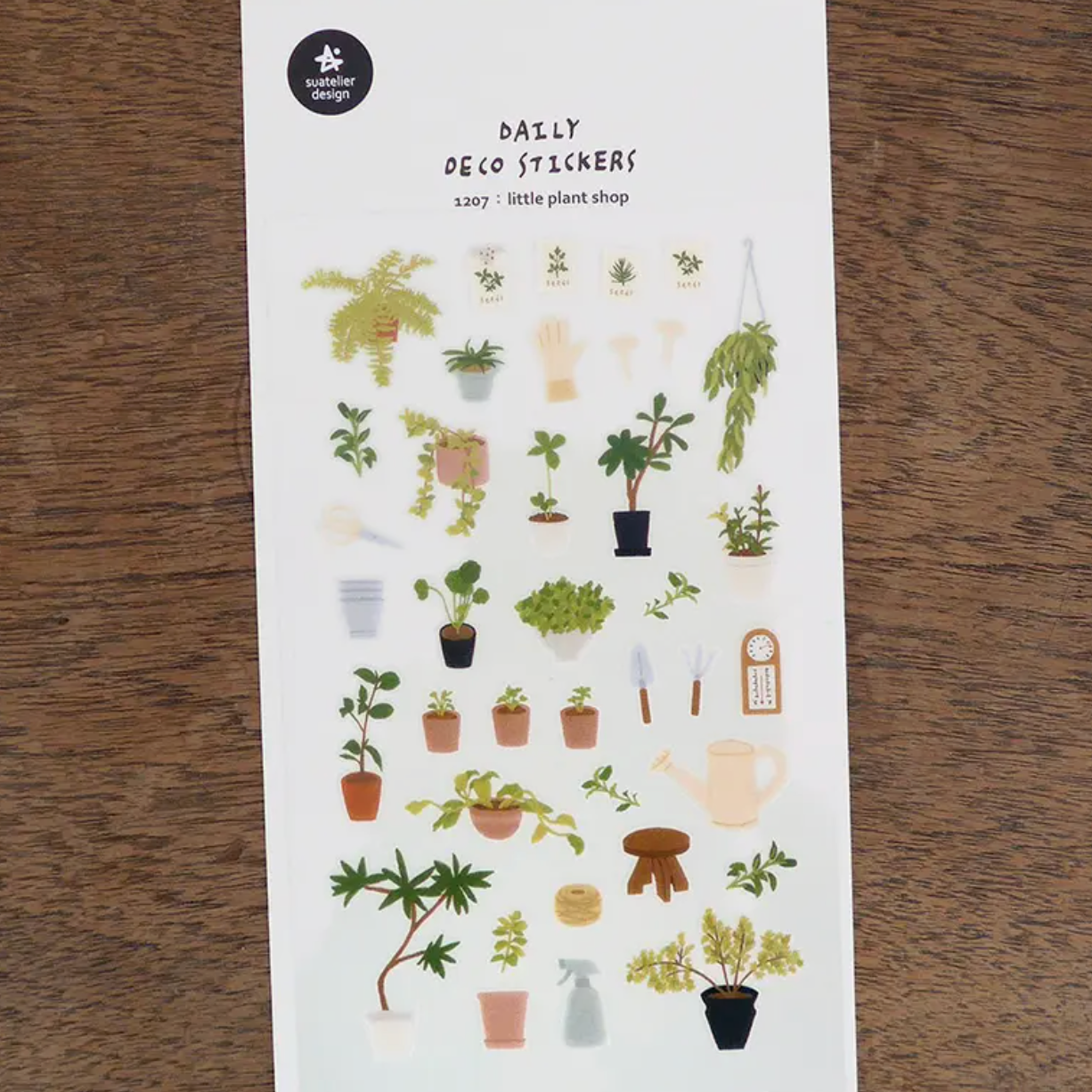 A sheet of plant-themed stickers labeled 'RALLY REPO STICKERS' and '150+ plant stickers' from the brand 'plant shop', displayed on a dark wood background.