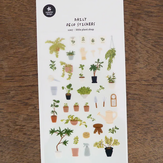 A sheet of plant-themed stickers labeled 'RALLY REPO STICKERS' and '150+ plant stickers' from the brand 'plant shop', displayed on a dark wood background.