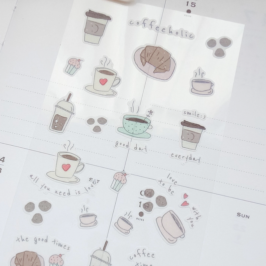A sheet of cute coffee-themed planner stickers displayed on a white dotted planner page. The stickers feature hand-drawn illustrations of coffee cups, pastries, and coffee beans in soft pastel colors, with handwritten labels like 'coffeekotic', 'smilej', and 'good day'.