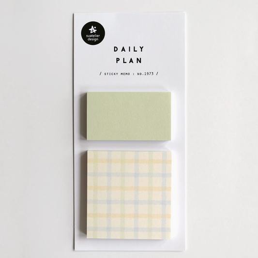 A daily planner sticky note set by Paper Garden on a white backing card, featuring a solid pale sage green note and a pale yellow and blue plaid note.