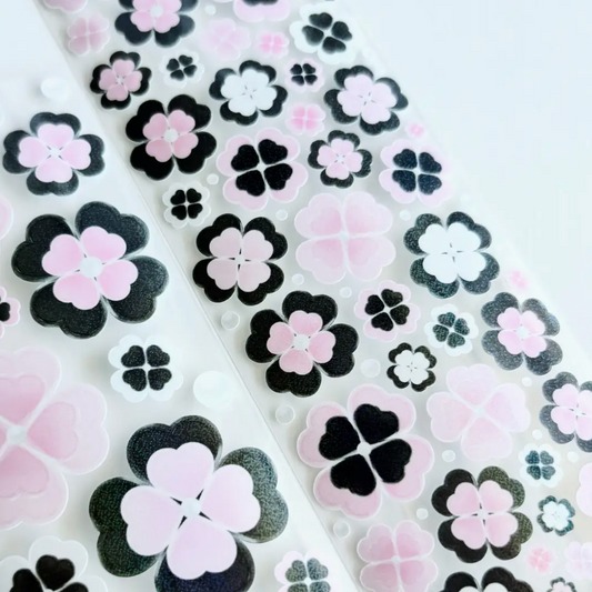 Two sheet of decorative adhesive stickers featuring pink, black, and white cherry blossom and clover motifs on a clean white background.
