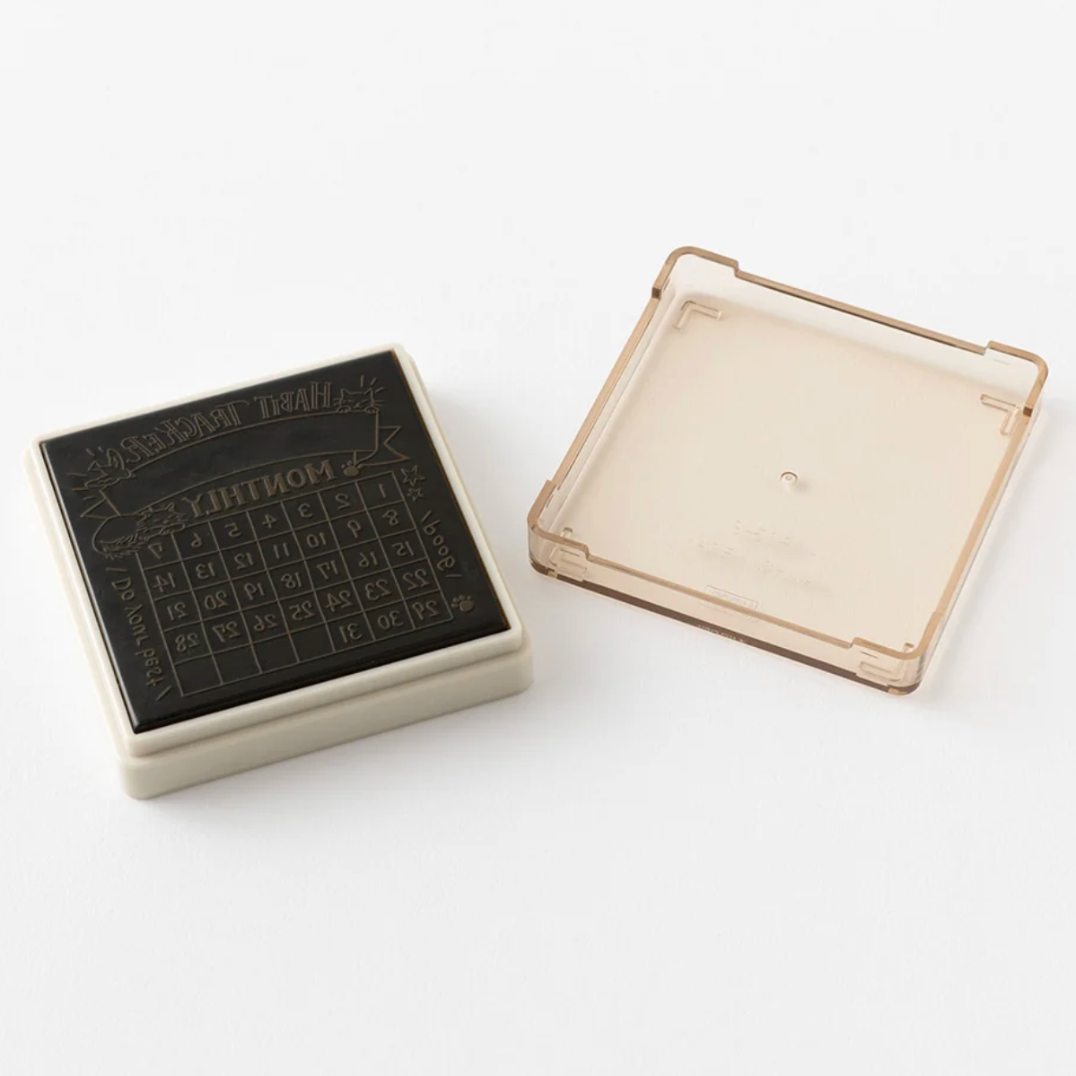 A square black rubber stamp with an embossed grid pattern and the word 'MUNTON' on the top, shown next to its translucent beige plastic cover on a white background.