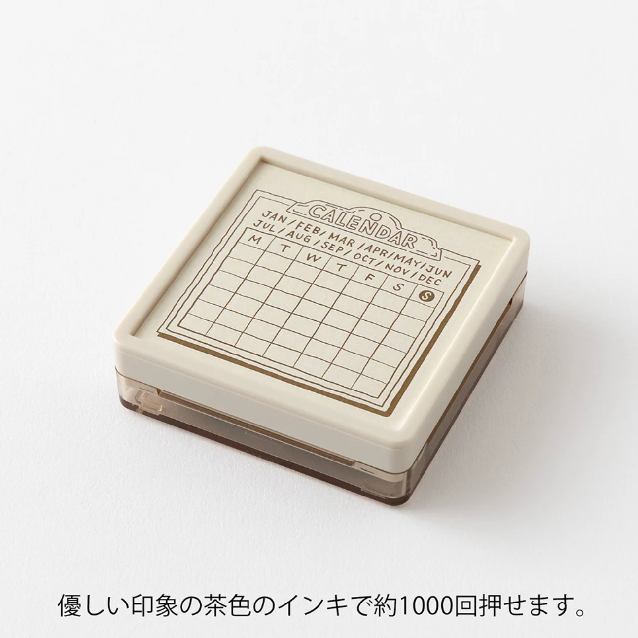 A square cream-colored ink pad case with a calendar-themed printed top panel, shown on a clean white background with Japanese text below.