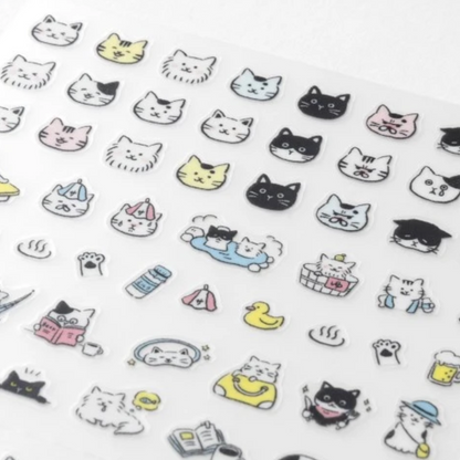 A sheet of clear adhesive stickers featuring cute, minimalist cartoon cat faces and small cat-themed icons in black, white, yellow, pink, and blue, displayed on a white background.