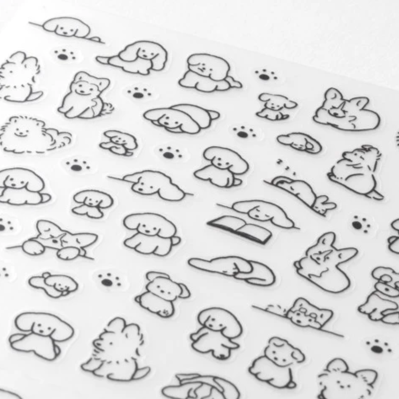 A sheet of clear nail stickers featuring cute black line-art illustrations of dogs, cats, rabbits, and paw prints on a white background.