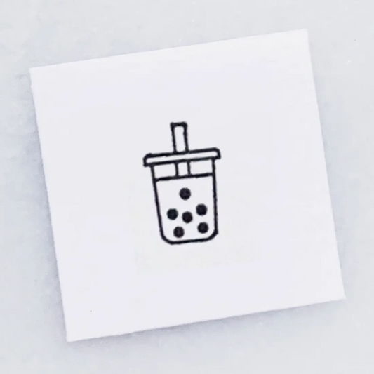 A square white card featuring a simple black line drawing of a boba tea cup with a straw, centered on a light gray background.