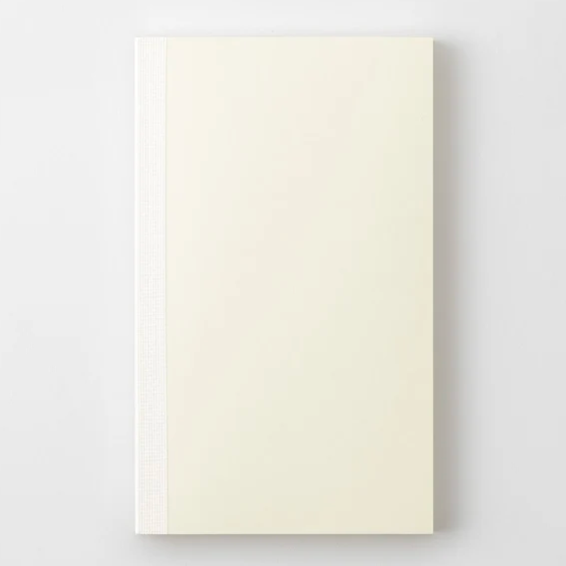 A cream-colored hardcover notebook with a textured spine, shown flat against a light gray background.